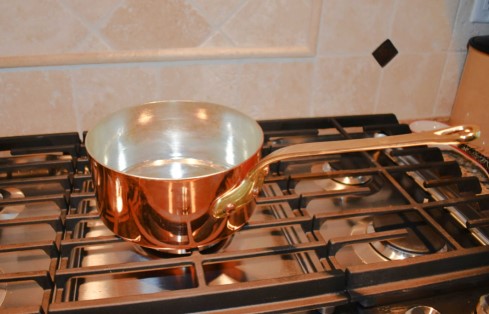 copper saucepan on grill
